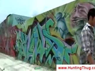 Valkoinen kaveri yrittää kohteeseen poimia ylös musta graffiti taiteilija